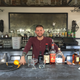 Eisner behind the bar with his CBD oil in the tiny blue bottle